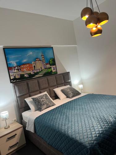 a bedroom with a bed and a painting on the wall at Guesthouse Nice room in Zadar