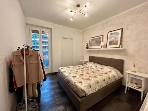 ein Schlafzimmer mit einem Bett und einem Mantel auf einem Kleiderständer in der Unterkunft Bilocale ristrutturato, Lingotto in Turin