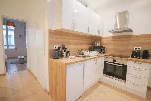 une cuisine avec des armoires blanches et un comptoir dans l'établissement Lille Centre - Nice, cozy and functional studio, à Lille
