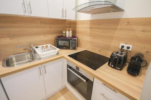 une petite cuisine avec un évier et une cuisinière dans l'établissement Lille Centre - Nice, cozy and functional studio, à Lille
