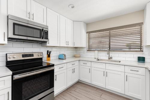 a kitchen with white cabinets and a black stove top oven at Casa Azul in Mesa