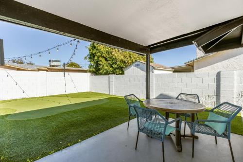 a patio with a table and chairs and a lawn at Casa Azul in Mesa