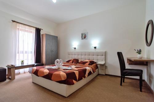 1 dormitorio con 1 cama y 1 silla en Pensiunea Diadis, en Cluj-Napoca