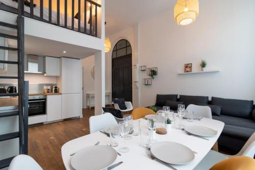 comedor y sala de estar con mesa blanca y sillas en Bright 3-bedroom 2-bathroom flat., en Lille