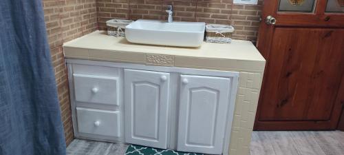 a bathroom with a sink next to a brick wall at villa3tours in Albion