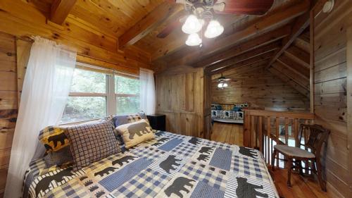 a bedroom with a bed in a log cabin at Yellow Cabin on the River in Newport