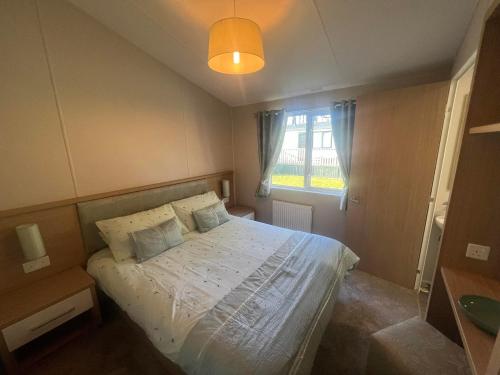 una piccola camera con letto e finestra di Pinehurst, 65 Golf View Lodge a Jedburgh