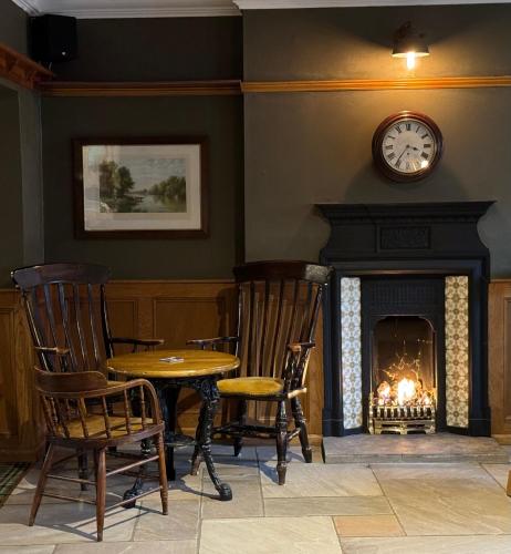 a room with a table and chairs and a fireplace at Middle House - Wensleydale, Yorkshire Dales in Askrigg