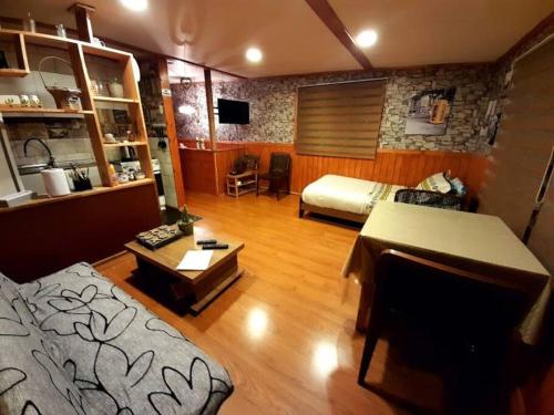 a large living room with a bed and a table at Cabaña León in Puerto Natales