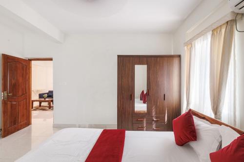 a bedroom with a bed with a red and white blanket at Mistyblue Stays in Bengaluru