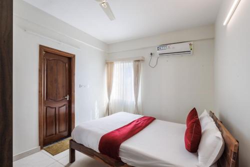 a bedroom with a bed and a wooden door at Mistyblue Stays in Bengaluru