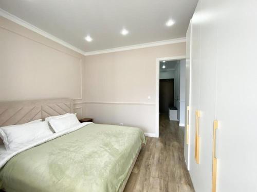 Dormitorio blanco con cama y pasillo en Highvill Ishim 412 en Astaná