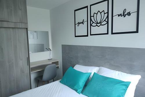 a bedroom with a bed with blue pillows and a desk at GURUS FR | Elegante Apartamento en parque acuático Dosquebradas in Dosquebradas