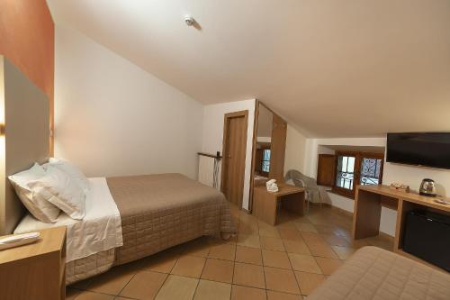 a hotel room with a bed and a flat screen tv at Hotel Sole in Assisi
