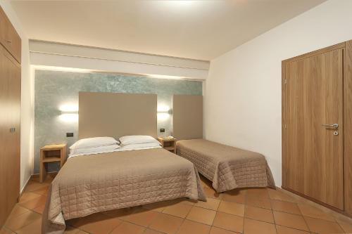 a hotel room with two beds and a cabinet at Hotel Sole in Assisi