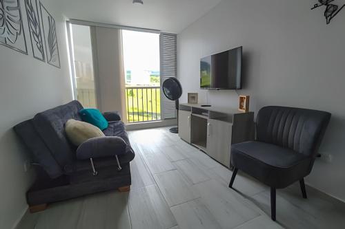 a living room with a couch and a chair and a television at GURUS FR | Elegante Apartamento en parque acuático Dosquebradas in Dosquebradas