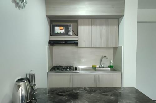a kitchen with a sink and a microwave at GURUS FR | Elegante Apartamento en parque acuático Dosquebradas in Dosquebradas