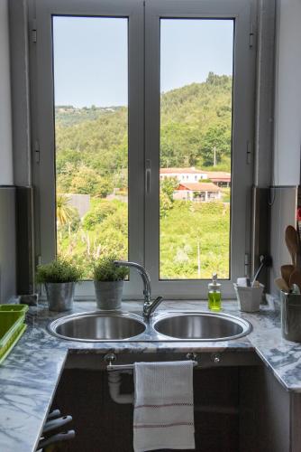 a kitchen counter with a sink and a window at Casa da Torre luxury villa in Braga in Braga