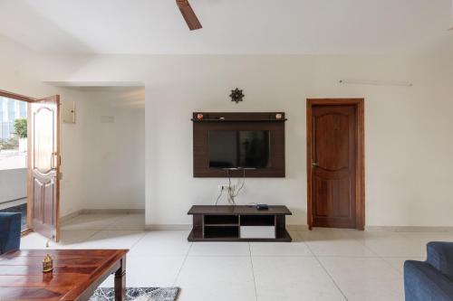 a living room with a tv on a wall at Mistyblue Stays in Bengaluru