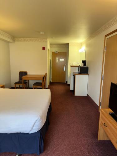 una habitación de hotel con una cama grande y una mesa en Peppermill Empress Inn, en Centralia