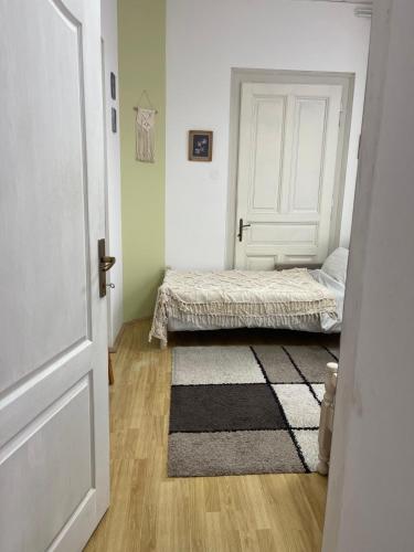 a bedroom with a bed and a door with a rug at Lennon in Vinkovci