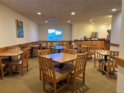 une salle à manger avec des tables et des chaises en bois dans l'établissement Peppermill Empress Inn, à Centralia