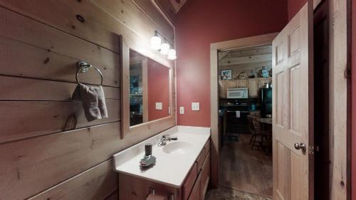 ein Bad mit einem Waschbecken und einem Spiegel in der Unterkunft Karen's Cabin in Pigeon Forge