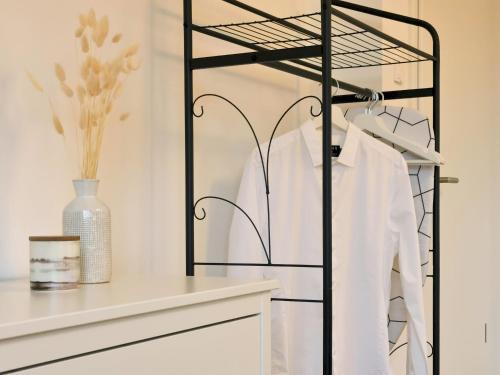 a black iron rack with a white shirt on a shelf at Fynbos Deluxe, Penthouse oder Balkon, Parkplatz in Straubing