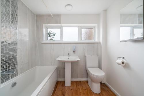een badkamer met een toilet, een wastafel en een bad bij Skyvillion-STEVENAGE Amazing 3Bed House, Garden, Free Off Street Parking for 2 Cars, WiFi in Stevenage