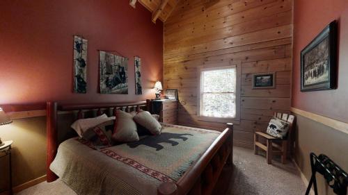 ein Schlafzimmer mit einem Bett in einem Zimmer mit Holzwänden in der Unterkunft Karen's Cabin in Pigeon Forge