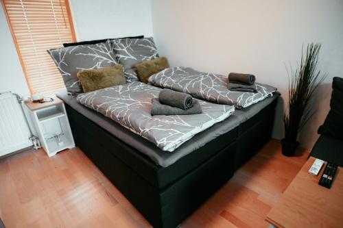 uma cama preta com almofadas num quarto em Schönbrunn Gardens Vienna Apartment em Viena