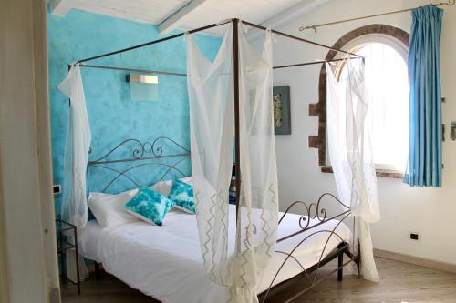 1 dormitorio con cama con dosel y paredes azules en Agriturismo Suite del Conte, en San Vincenzo