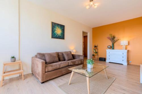 ein Wohnzimmer mit einem Sofa und einem Tisch in der Unterkunft Bright one bedroom apartment with parking in La Madeleine