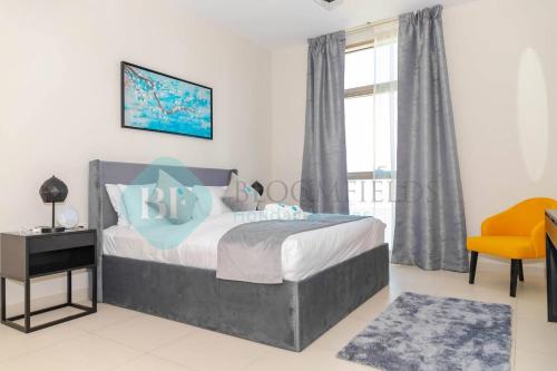 um quarto com uma cama e uma cadeira amarela em Modern 1 Bedroom In Reflections em Abu Dhabi