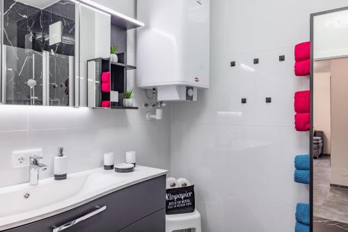 ein Bad mit einem Waschbecken und einem Spiegel in der Unterkunft "Home to Enjoy" Premium Appartement in Sonnenalpe Nassfeld
