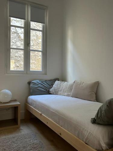 - un lit dans une chambre avec fenêtre dans l'établissement Studio Neuf Hyper Centre St Germain - Proche RER, à Saint-Germain-en-Laye