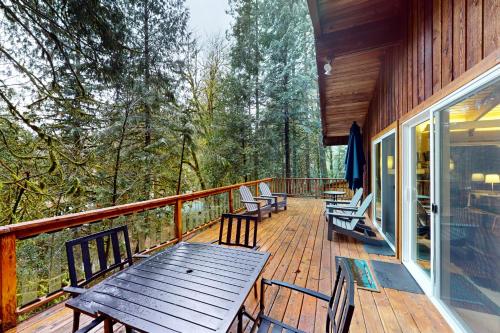 a wooden deck with chairs and a wooden table at Lookout Lair in Rhododendron