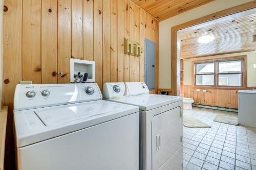 uma máquina de lavar e secar roupa num quarto com paredes de madeira em Waterfront North Hero Home with Screened Porch em North Hero