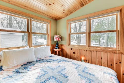 een slaapkamer met een bed in een kamer met ramen bij Waterfront North Hero Home with Screened Porch in North Hero