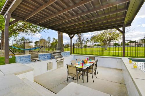 a patio with a table and chairs under a pergola at Your Stylish Getaway to Desert Fun and Relaxation in Indio