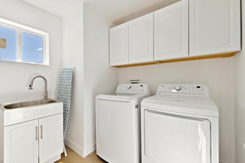 a white laundry room with a washer and dryer at Your Stylish Getaway to Desert Fun and Relaxation in Indio
