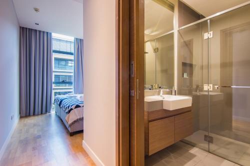 a bathroom with a sink and a bed and a mirror at Cityscape lofts Living in City Walk 2BR Unit in Dubai