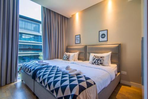 a bedroom with a bed with a large window at Cityscape lofts Living in City Walk 2BR Unit in Dubai