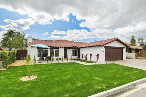 a house with a green lawn in front of it at Your Stylish Getaway to Desert Fun and Relaxation in Indio