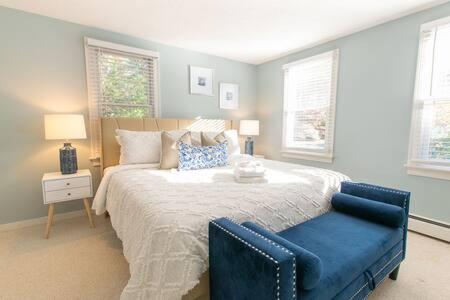 - une chambre avec un grand lit et une chaise bleue dans l'établissement Spacious Stone Fire Pit Game Room A C, à Barnstable