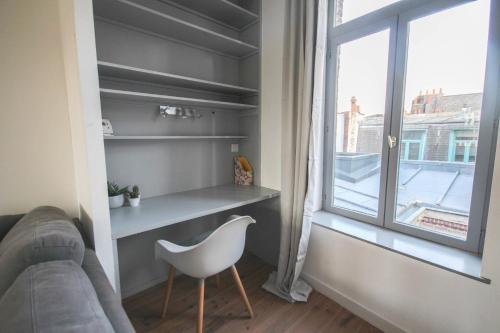 - un salon avec une chaise blanche et une fenêtre dans l'établissement Charming 60m2 apartment, à Lille