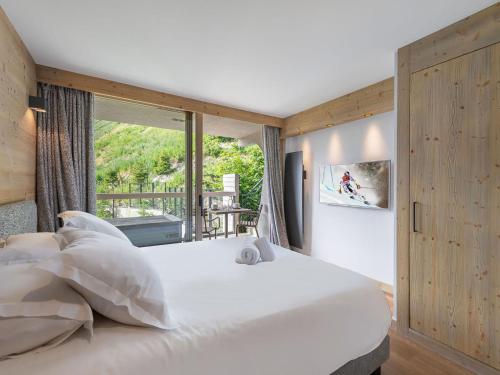 a bedroom with a large white bed and a window at Appartement Courchevel 1550, 4 pièces, 9 personnes - FR-1-562-75 in Courchevel