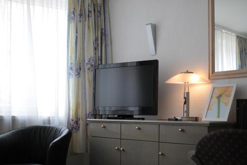 a living room with a tv and a window at Hotel Goldener Anker in Coburg