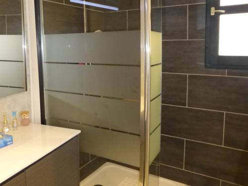 une douche avec une porte vitrée dans une salle de bain dans l'établissement Appartement Rénové 5 Pers avec WIFI et Animaux Acceptés - FR-1-512-273, à Brides-les-Bains