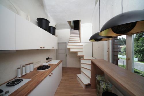 una cocina con armarios blancos y escaleras en una casa en Strelnieku Avenue Apartment Jurmala, en Jūrmala